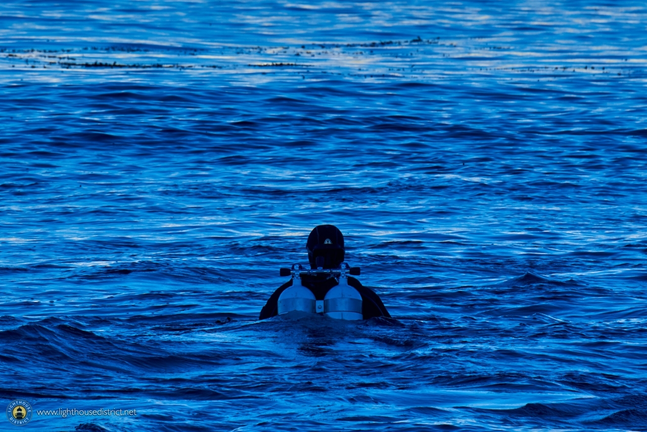 Scuba Diver emerging from deep blue ocean ocean waters